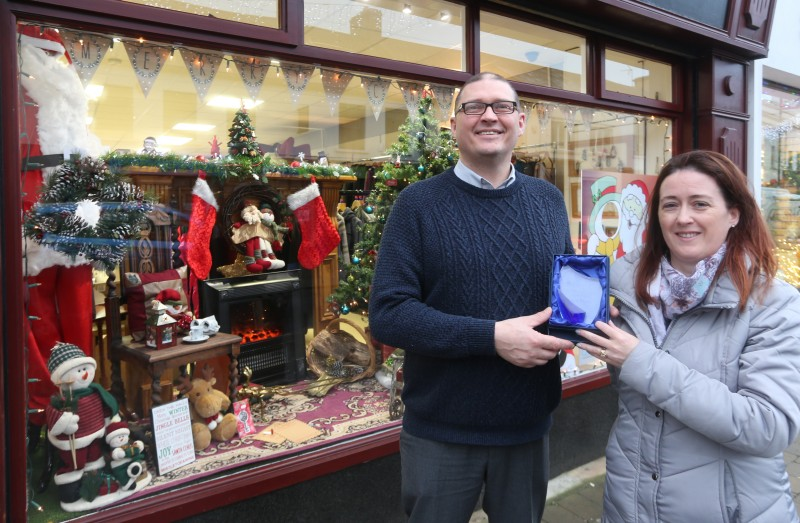 Terry Beatty from Can Can Bazaar receives the prize for taking second place in the Christmas Window Competition from Causeway Coast and Glens Borough Council Officer Catrina McNeill.