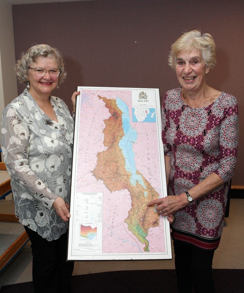 Yvonne Boyle and Joyce McMullan from the Zomba Action Project point to the location of Zomba on a map of Malawi.