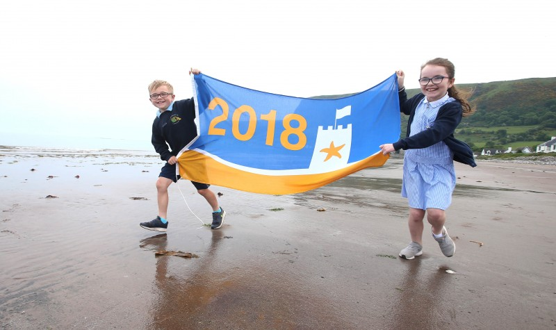 Helping to fly the prestigious Seaside Award flag at Waterfoot Beach in Glenariff are Darra and Orlaith, pupils at St Patrick's Primary School. The beautiful stretch of coastline within the stunning 'Queen of the Glens' is one of a number of locations across the Causeway Coast and Glens Borough Council area selected for an accolade at this year's Blue Flag and Seaside Awards.