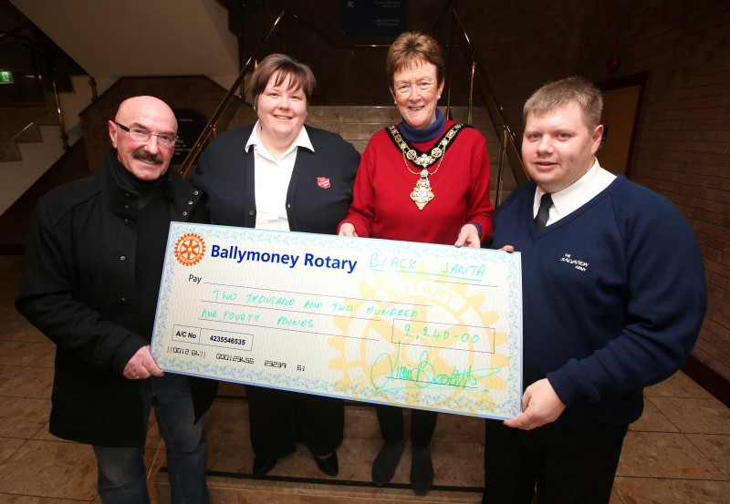 Jane Marie Cook and Timothy Cook representing the Salvation Army receive their donation from Ballymoney’s Black Santa Liam Beckett alongside the Mayor of Causeway Coast and Glens Borough Council, Councillor Joan Baird OBE.