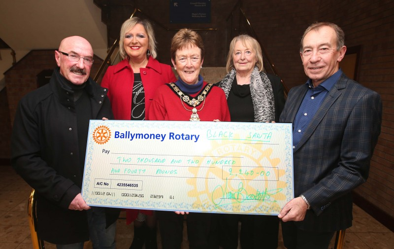 Claire Bleakley, Agnes McConville and David McKeown representing the Samaritans receive their donation from Ballymoney’s Black Santa Liam Beckett alongside the Mayor of Causeway Coast and Glens Borough Council, Councillor Joan Baird OBE.