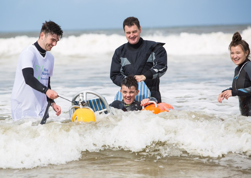 Mae Murray Foundation volunteers Gary Fekkes and Rodney Crawford help two young siblings enjoy  the surf at the launch of Benone as Northern Ireland’s first all inclusive beach.