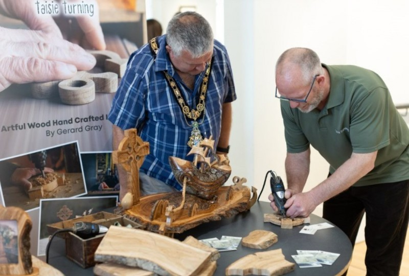 Gerard Gray, of Taisie Turning, demonstrates his wood turning skills to the Mayor of Causeway Coast and Glens Borough Council, Councillor Ivor Wallace. Gerard is one of the local creatives involved in the Northword Storytagging Project.
