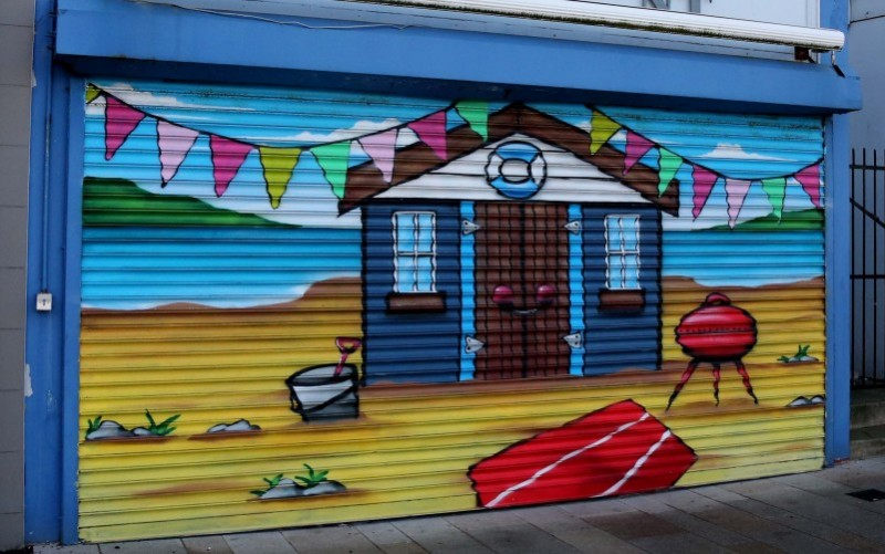 Shutter art created on a property on Eglinton Street in Portrush through the Revitalise scheme, funded by the Department for Communities (DfC) and delivered by Causeway Coast and Glens Borough Council.