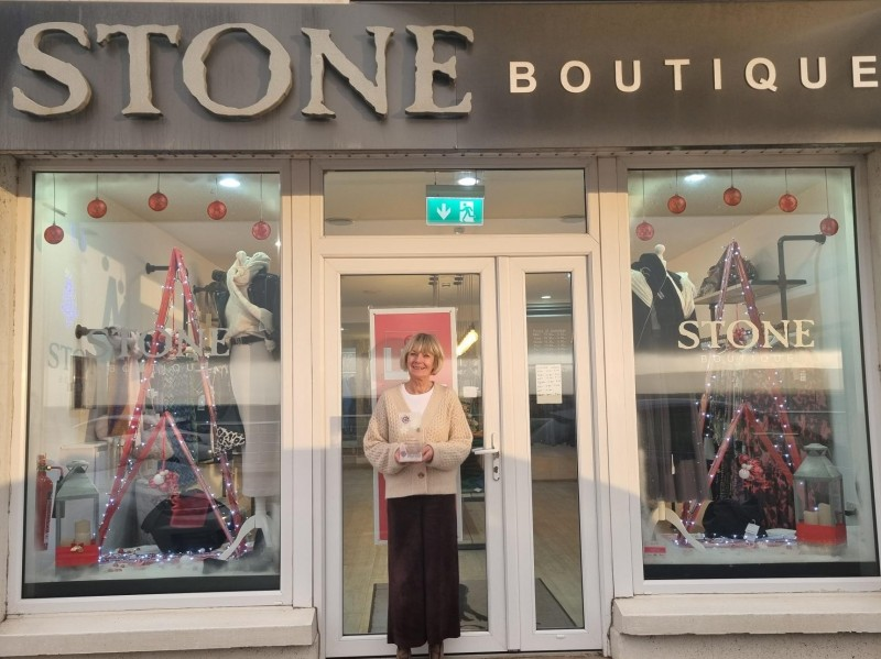 Stone Boutique staff member standing between the shop’s winning window dressing