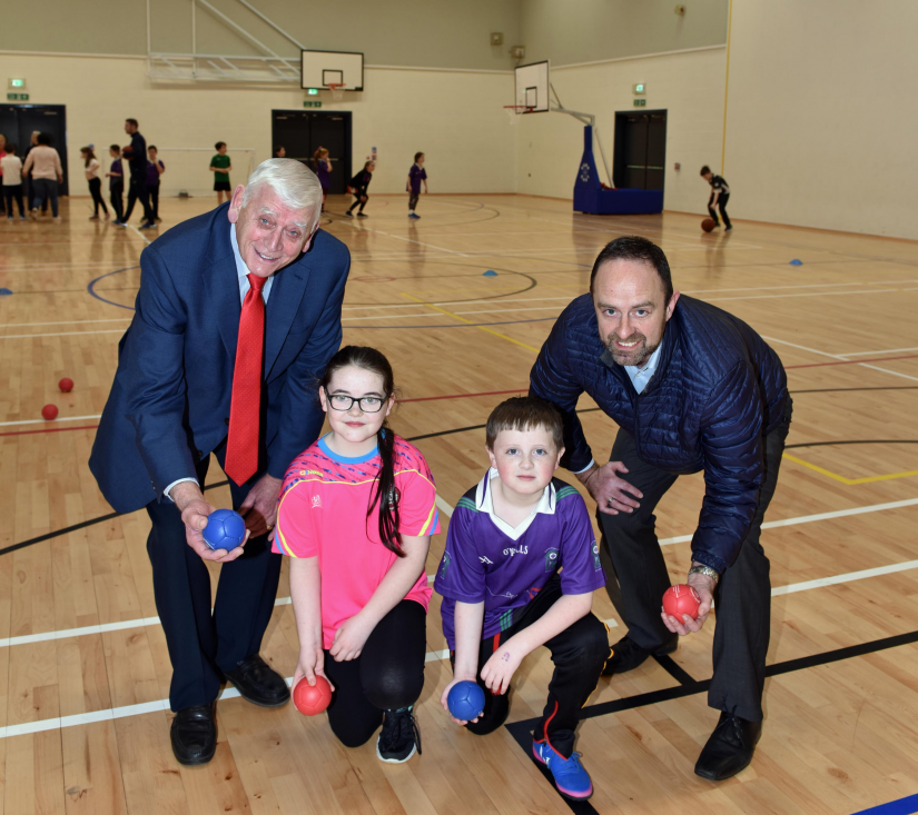 Cara from St Canice's Primary School and Oisin from Gaelscoil Neachtain enjoy activities in the main hall during the official opening of Dungiven Sports Centre with Willie Devlin from Sport NI and Alderman William King from Causeway Coast and Glens Borough Council.