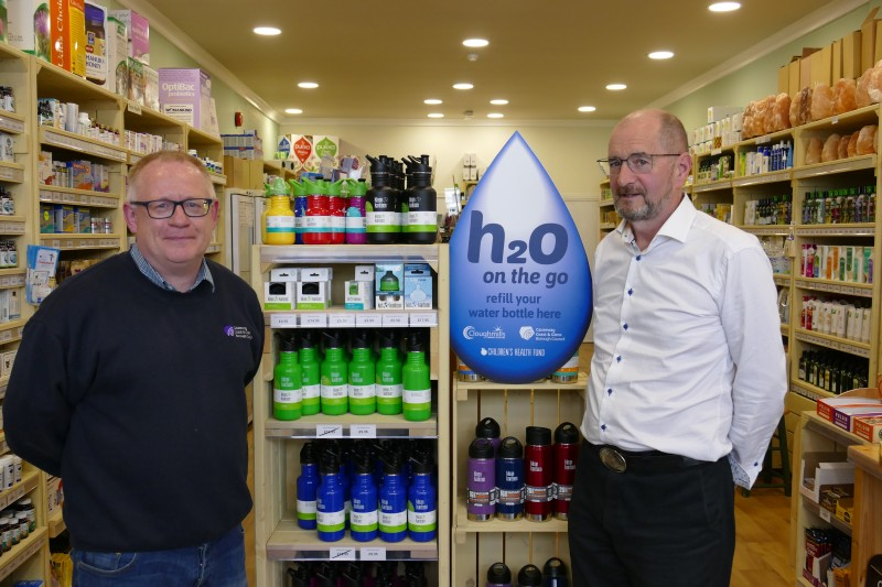 Declan Donnelly, Environmental Resource Officer, Causeway Coast and Glens Borough Council pictured with Ivor Bolton, from The Real Health Store Coleraine and the display of subsidised children’s steel water bottles that are now available to purchase in store.
