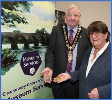 Mayor of Causeway Coast and Glens, Councillor Stephen Callaghan alongside Sally Forwood holding donated artefacts.