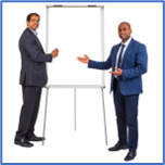 A group of men in suits standing next to a white board training others